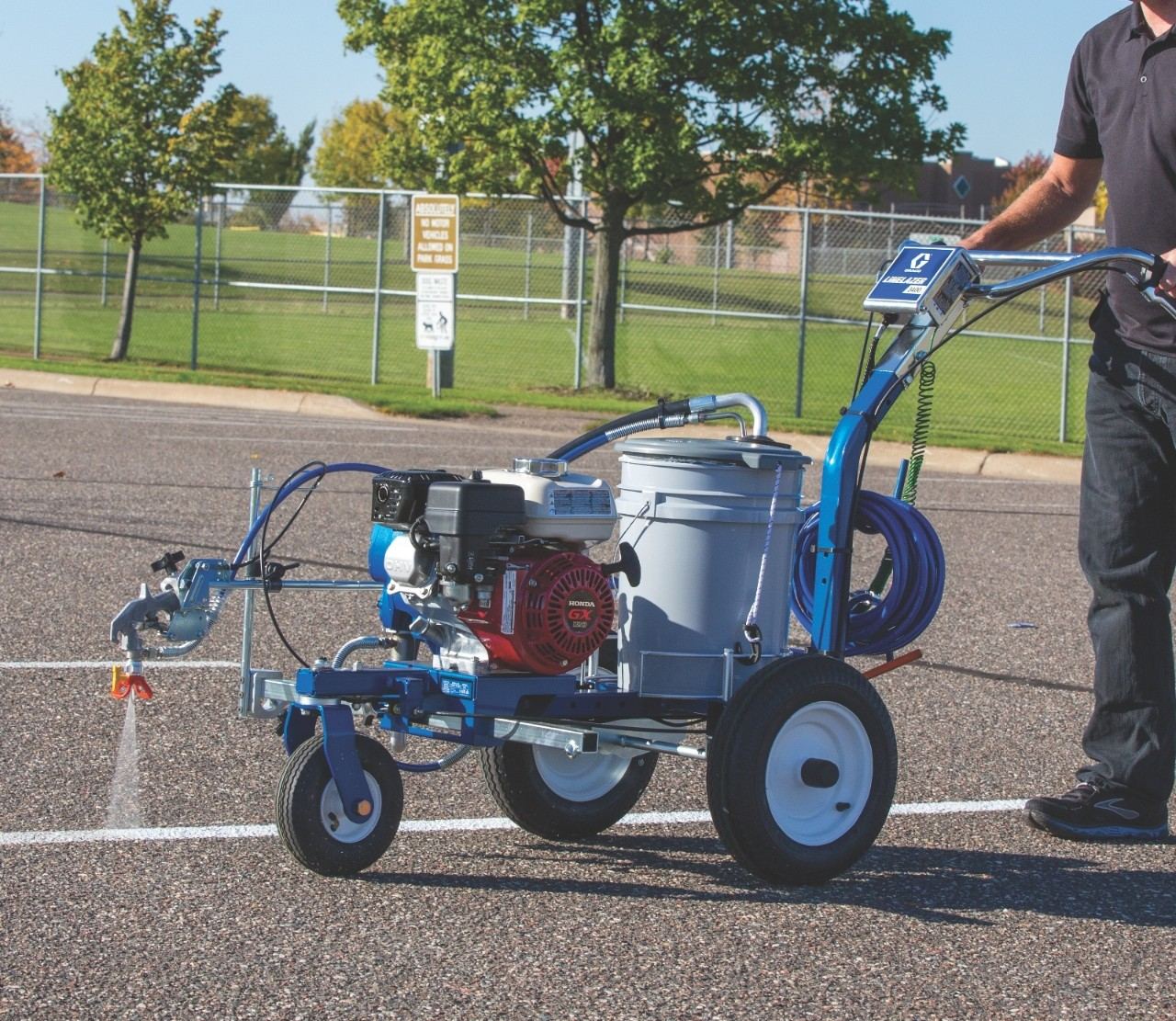 Line striping machine on asphalt at dusk